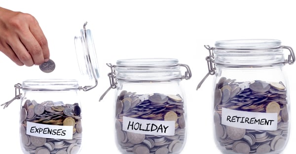 Three coin jars labelled expenses, holiday and retirement